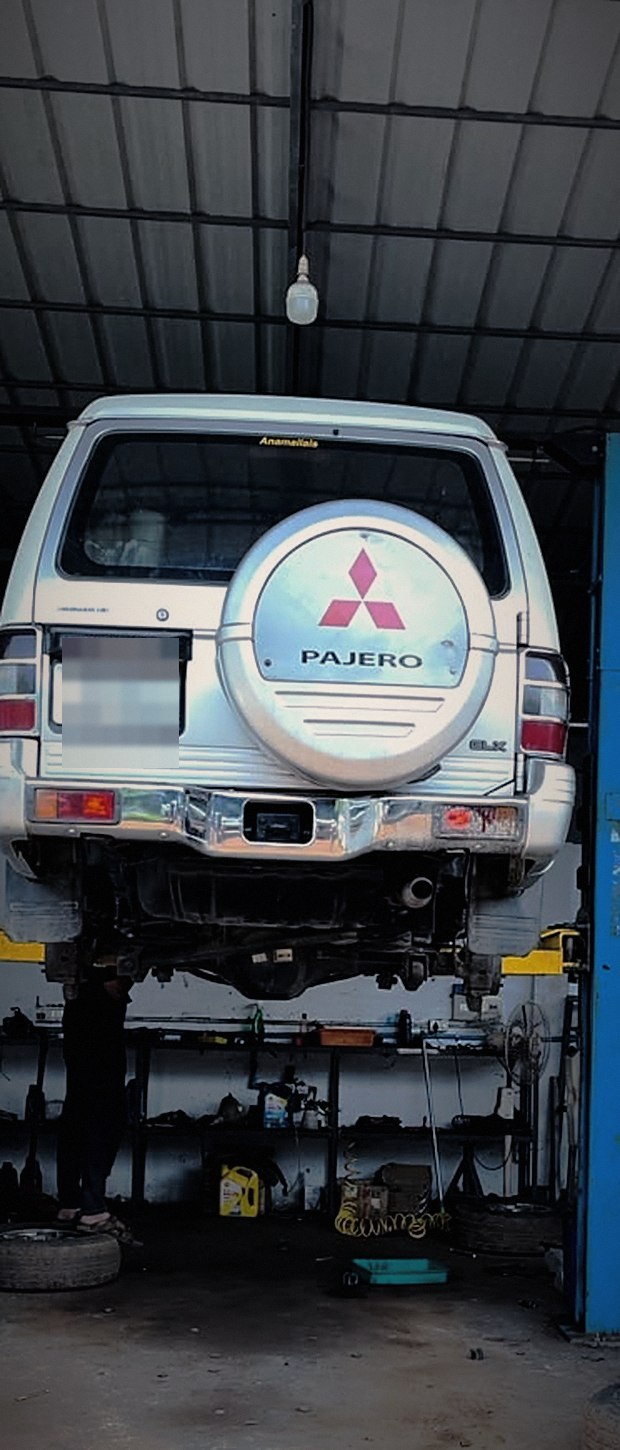 A Mitsubishi Pajero raised on the two-post lift